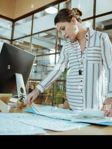 dark haired businesswoman with hair bun working in the offic