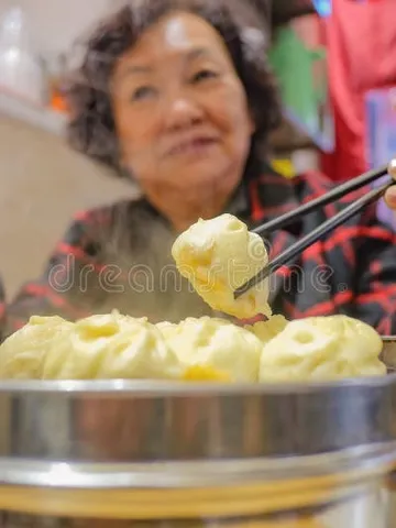 defocus senior asian women eating small steam buns in chines