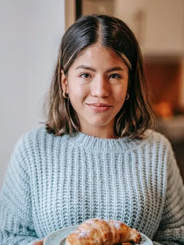 latin american woman near coffee mug and bun in kitchen free
