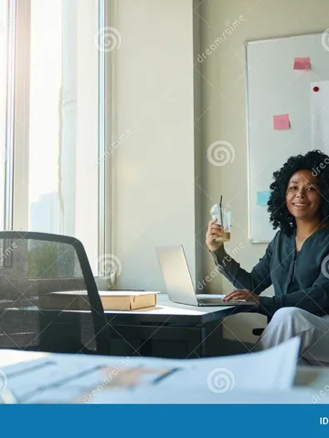 woman with curly hair at workplace in the office stock image