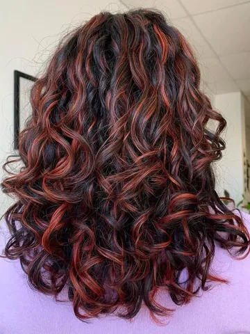 dark red curly hair with highlights